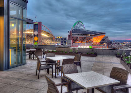 a terrace with tables and chairs and a view of a stadium