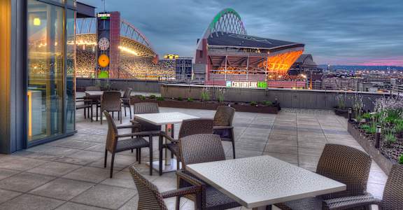 a terrace with tables and chairs and a view of a stadium