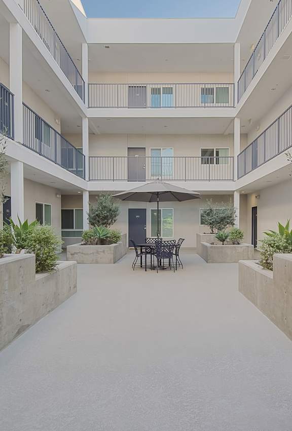 A modern building with a balcony on the second floor at Valley Street Apartment, Los Angeles, CA, 90057