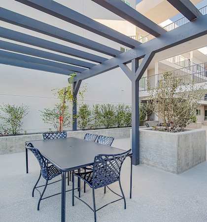 A patio with a table and chairs under a pergola at Valley Street Apartment, Los Angeles, CA, 90057