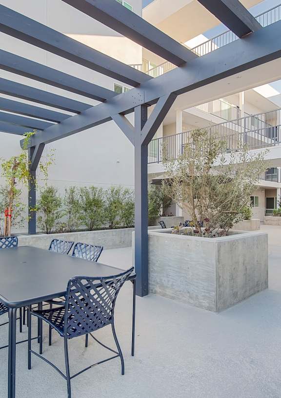 A courtyard with a concrete floor and a white building with balconies at Valley Street Apartment, Los Angeles, CA, 90057