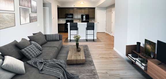 a living room with a couch and a table and a kitchen