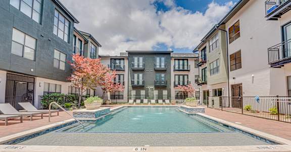 A swimming pool surrounded by apartment buildings.