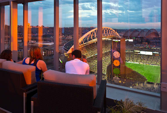 a view of a stadium from the top of a skyscraper overlooking a baseball game