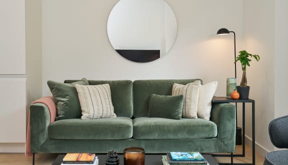 a living room with a green couch and a black coffee table