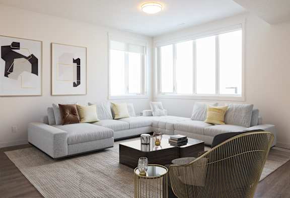 A living room with a grey couch, a coffee table, and two abstract paintings on the wall.