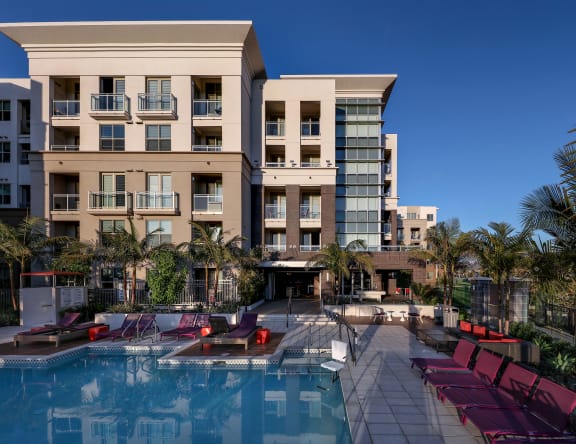 A large building with a pool in front of it. at West Park Apartments, California, 92108