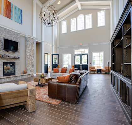 a large living room with a stone fireplace and leather furniture at The Ledges Apartment Homes, Groton, 06340