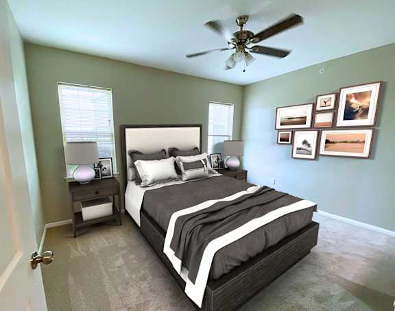 A bedroom with a large bed and a ceiling fan.