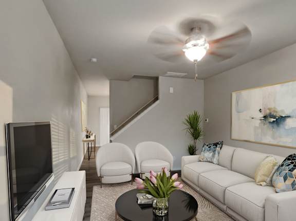 a living room with white furniture and a ceiling fan