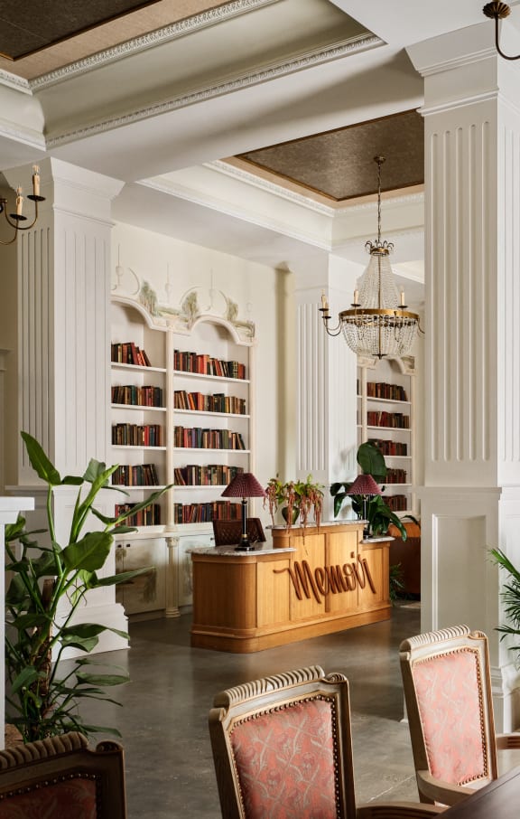 a lobby of a hotel with a reception desk and a library