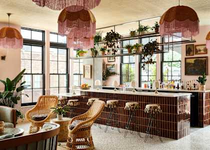 a bar with chairs and a counter in a room with windows