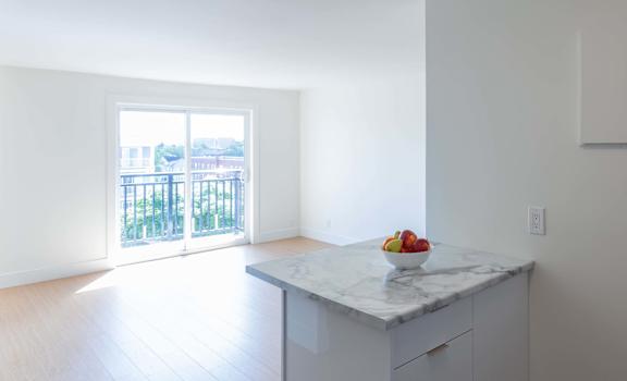 A kitchen with a marble countertop and a bowl of fruit on it.