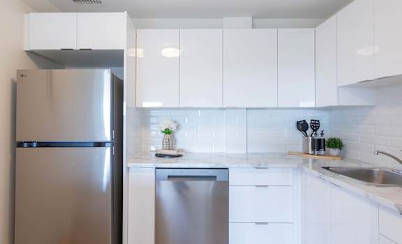 A modern kitchen with a stainless steel refrigerator and dishwasher.