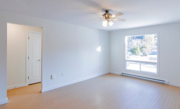 A room with a ceiling fan and a window.