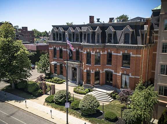 an aerial view of a red brick building with an flag at The Knights @ 506 Delaware Apartments, Buffalo, NY 14202