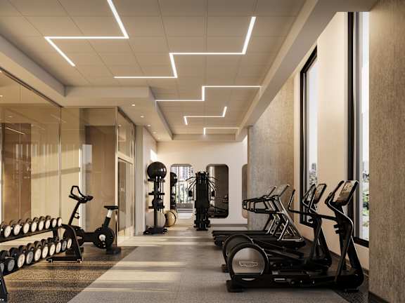A gym with treadmills, elliptical machines, and dumbbells.