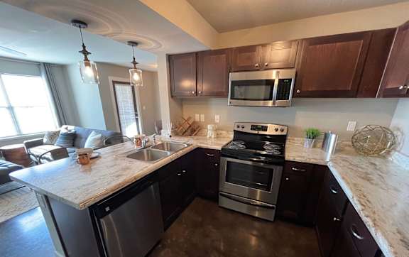 A modern kitchen with stainless steel appliances and wooden cabinets.