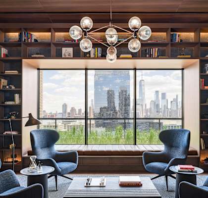 a living room with a large window and chairs and a table at The Lively, New Jersey, 07302