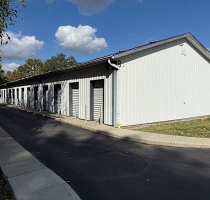 A white storage building with roll-up doors.