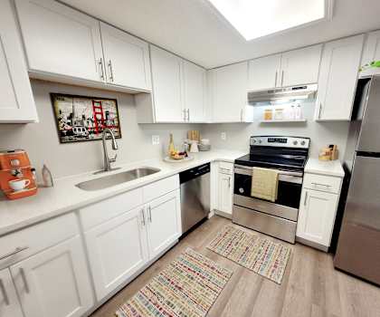 a kitchen with white cabinets and stainless steel appliances