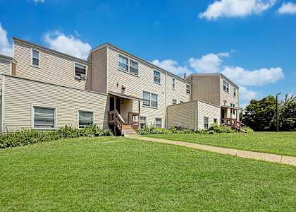 A row of houses with a green lawn in front.