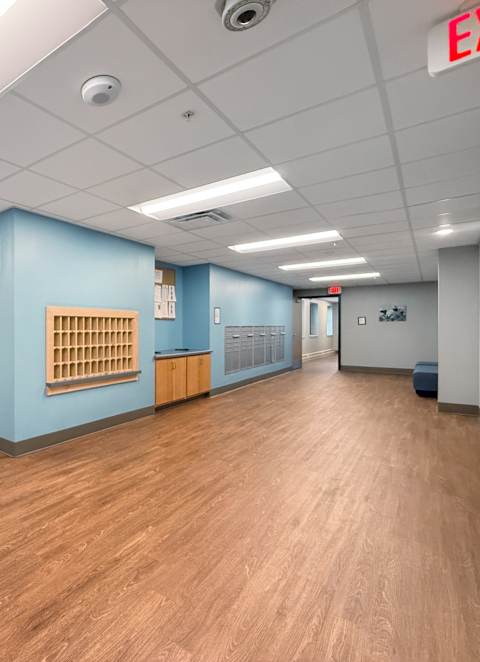 A room with a carpeted floor and two wooden doors.