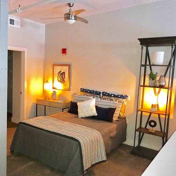 a bedroom with a bed and a ceiling fan
