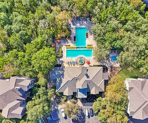 An aerial view of a house with a pool surrounded by trees at Legends on the Green Apartments, San Antonio, TX