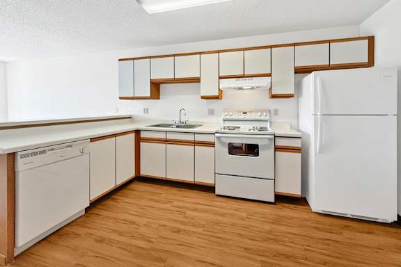 A kitchen with wooden cabinets and white appliances.