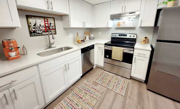 a kitchen with white cabinets and stainless steel appliances