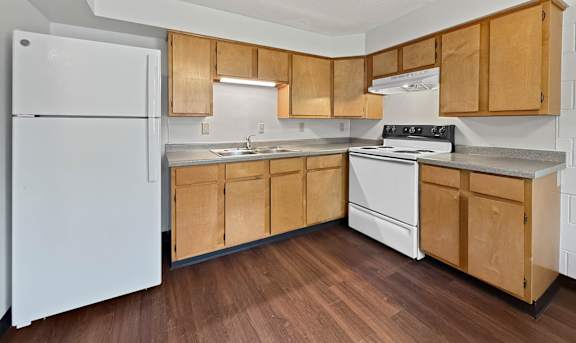 A kitchen with wooden cabinets and white appliances.