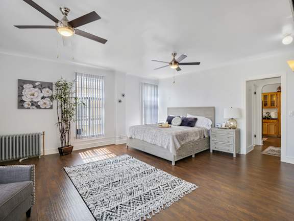 Spacious bedroom with large comfortable bed and windows at The Langham Apartments, California