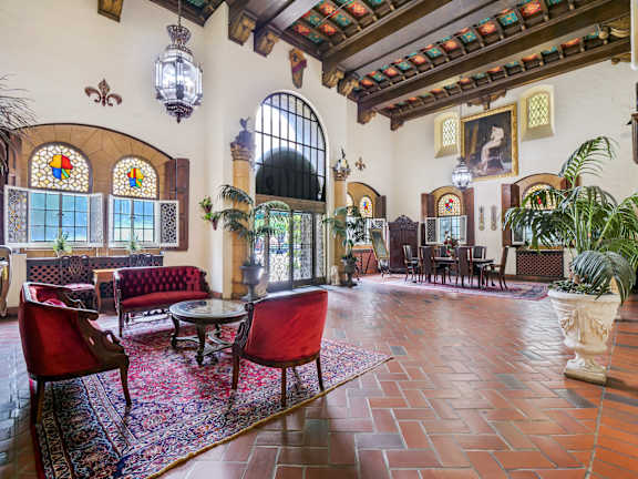 Beautiful common living room with wooden table and chairs at The Langham Apartments, Los Angeles