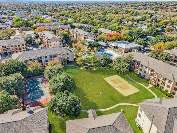 A bird's eye view of a residential area with a tennis court and a basketball court  at The Canyons Apartments, Texas, 76116