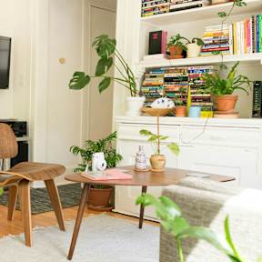 A living room with a chair, a table, and a TV.