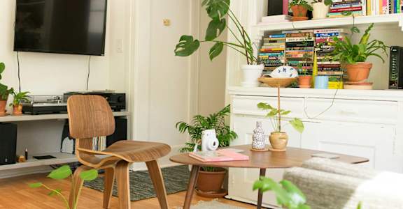 A living room with a chair, a table, and a TV.