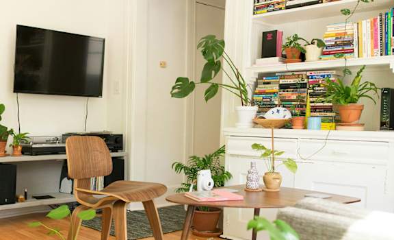 A living room with a chair, a table, and a TV.
