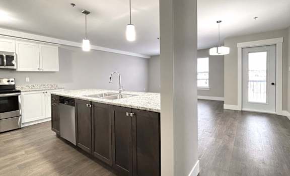 A modern kitchen with dark wood cabinets and a white countertop.