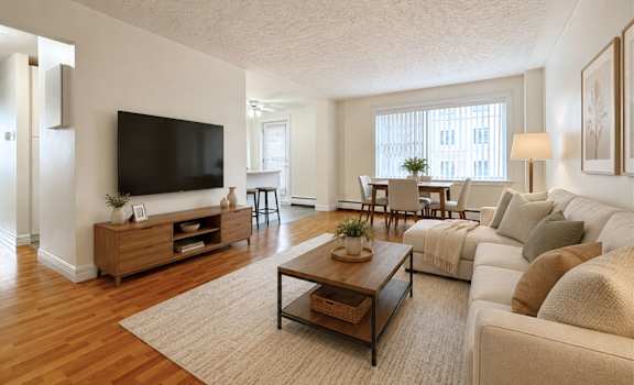 A living room with a white couch, a wooden coffee table, and a flat-screen TV.