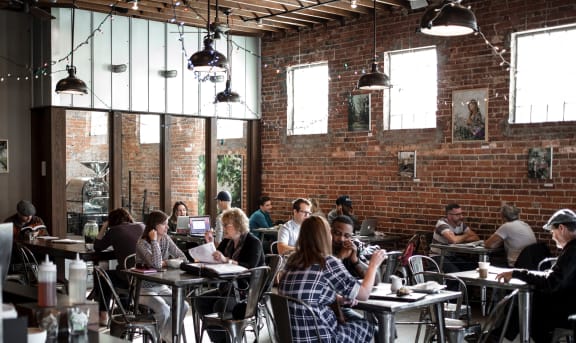 a group of people sitting at tables in a restaurant