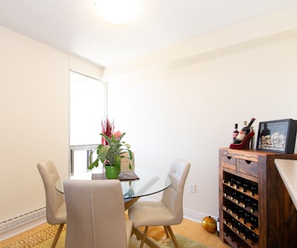 A dining room with a glass table and chairs.