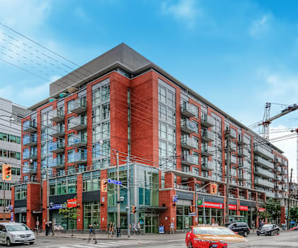 A red and grey building with a car in front of it.