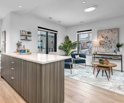 A modern kitchen with a white countertop and wooden cabinets.