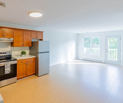 A kitchen with wooden cabinets and a refrigerator.