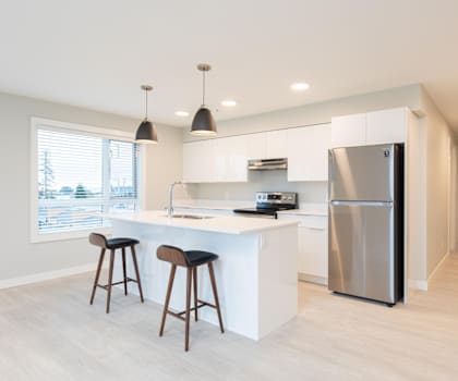 A modern kitchen with a white countertop and a stainless steel refrigerator.