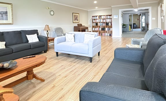 A living room with a grey couch, a white couch, and a wooden coffee table.