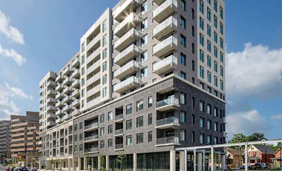 A modern multi-story building with balconies and large windows.