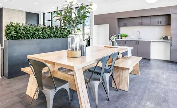 A modern dining area with a wooden table and chairs.