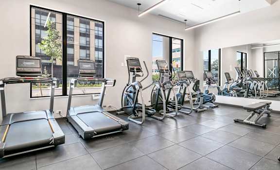 A spacious gym with treadmills, elliptical machines, and other exercise equipment.